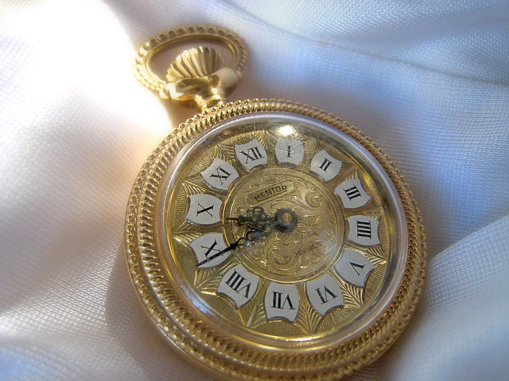 Montre à gousset ancienne à chiffres romains illustrant les grandes dates d'histoire au brevet